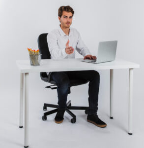 Hombre sentado correctamente frente al escritorio