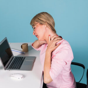 Mujer con dolor de cuello en la oficina